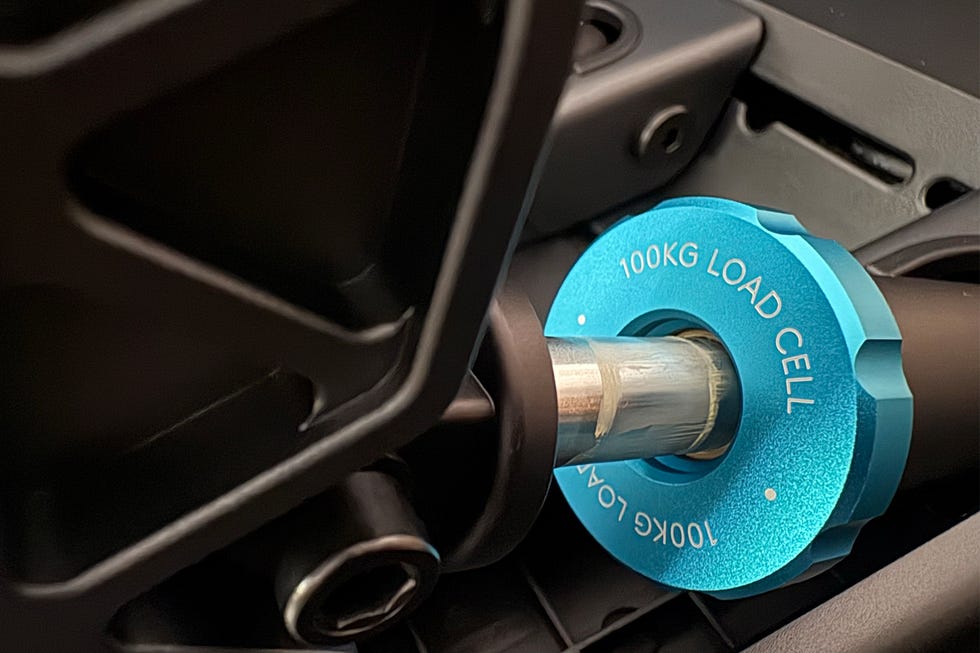Close-up of a blue load cell with a 100kg capacity, partially visible against a dark background.