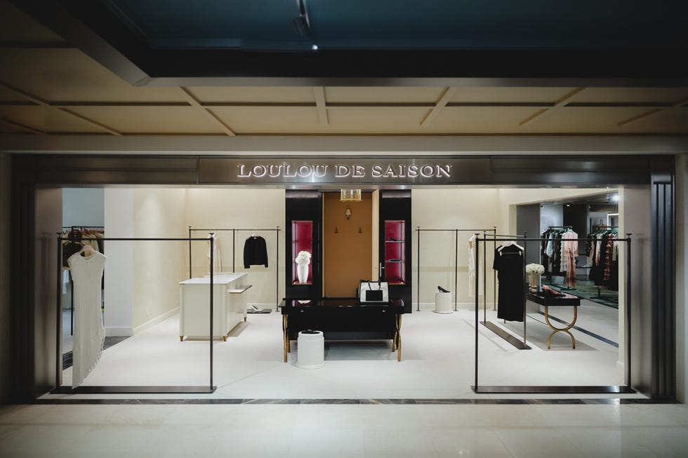 Boutique store entrance displaying clothing racks and a modern interior design with the sign "LOULOU DE SAISON.
