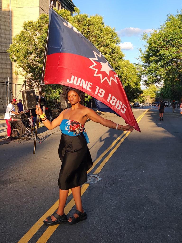 Photo of a woman holding a Juneteenth flag