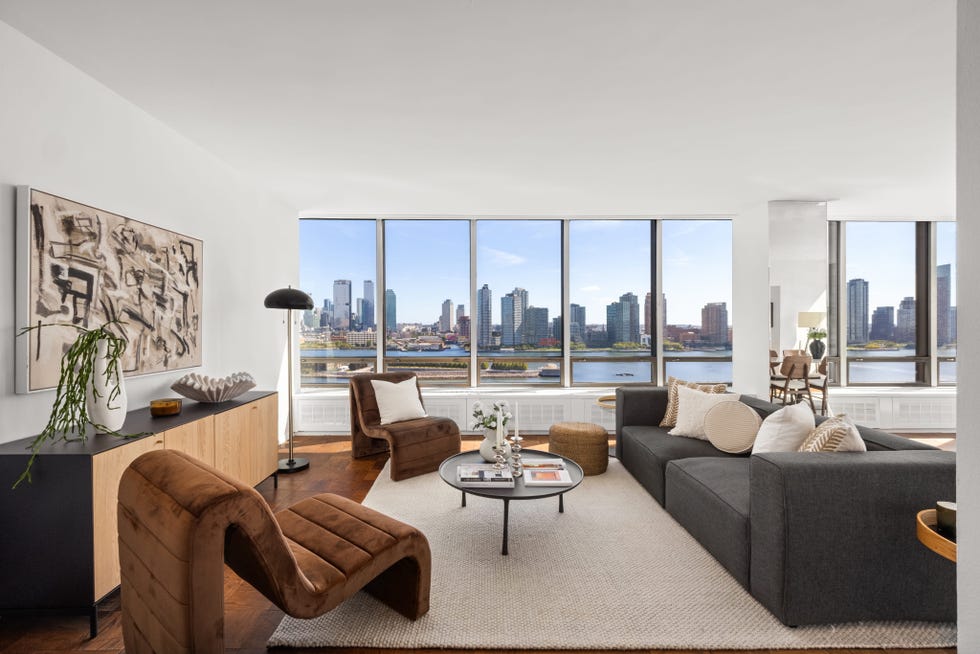 Modern living room with city skyline view, featuring stylish furniture and decorative elements. Modern living room with city skyline view, featuring stylish furniture and decorative elements.