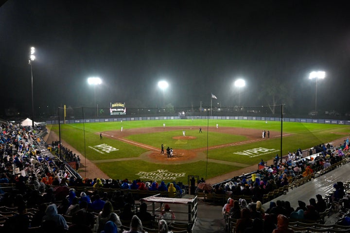 Fans watch in the rain during the seventh inning of the inaugural Women's Professional Baseball League game between the Los Angeles Queens and the New York Heights on Saturday in Springfield, Illinois. (AP Photo/Lexie Knight)