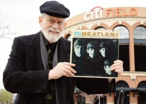 Dennis Livesey holds his vintage “Meet The Beat­les!” album cover at the former location of Shea Stadium, currently the parking lot of Citi Field. Photo: David Paone