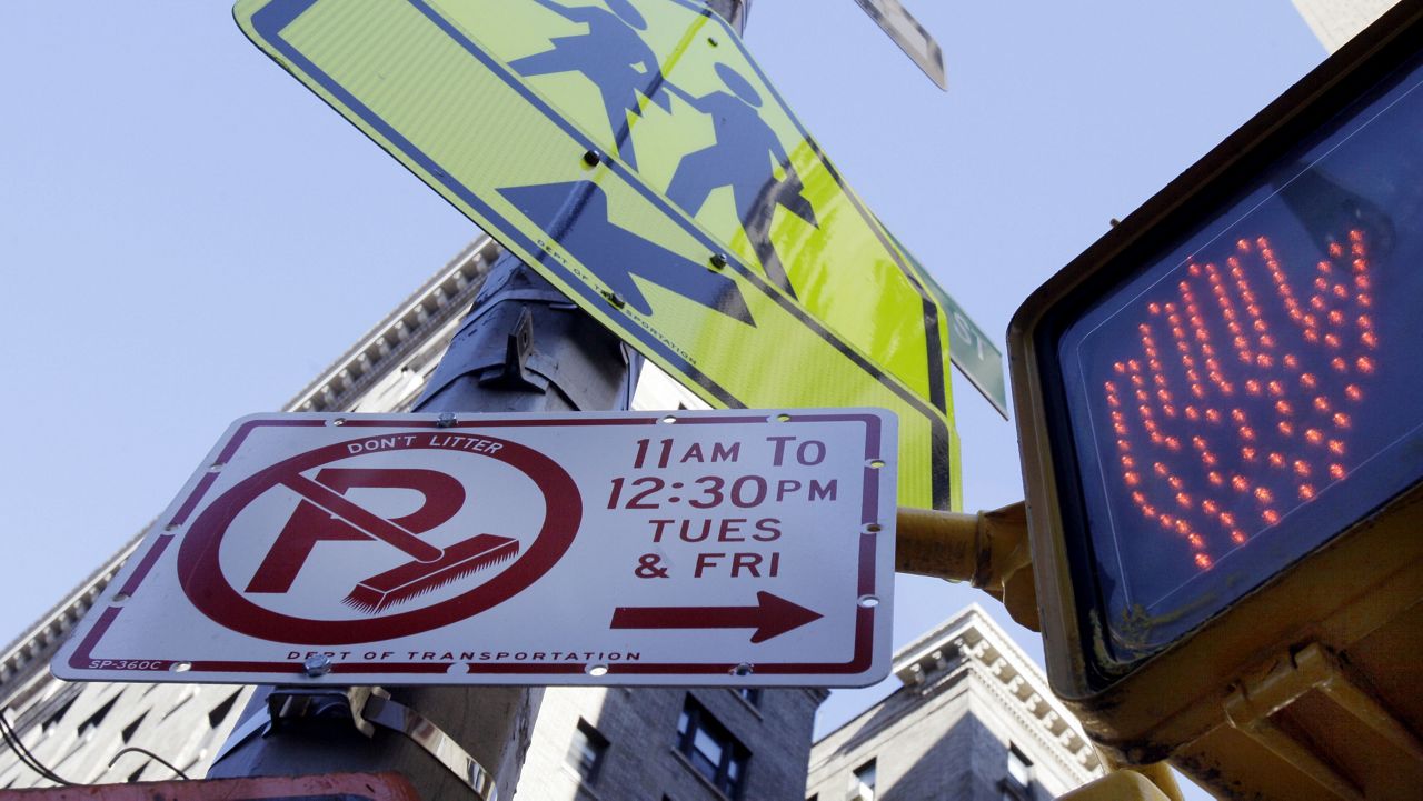 A sign posted for alternate-side of the street parking regulations shares a street corner lamppost on New York's Upper West Side, Tuesday, Feb. 15, 2011. New York City Council Speaker Christine Quinn wants to ease the burden of so-called alternate-side parking by reducing the number of days that residents on some blocks must move their cars. (AP Photo/Richard Drew)