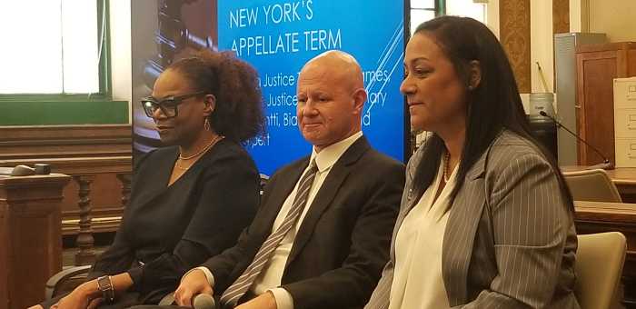 three people sitting down wearing business attire