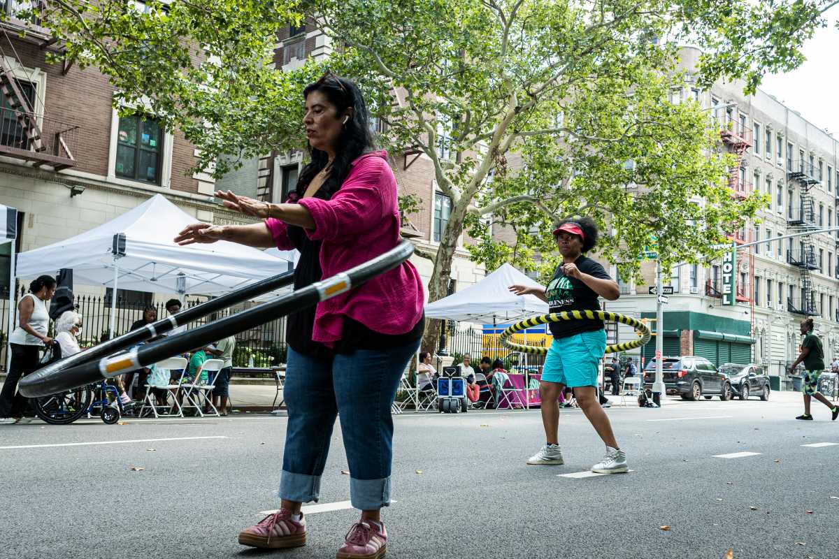 Founder of Hula Hoop 366 leads a family in a hula exercise to demonstrate the different hula hoop styles.
