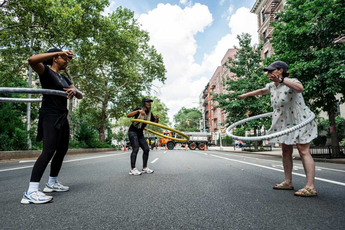 Founder of Hula Hoop 366 leads a family in a hula exercise to demonstrate the different hula hoop styles.
