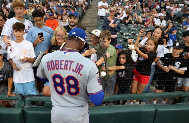 Mets left fielder Luis Robert Jr. signs autographs for fans before a game against the White Sox on Friday, Aug. 21, 2026, at Rate Field. (Chris Sweda/Chicago Tribune)