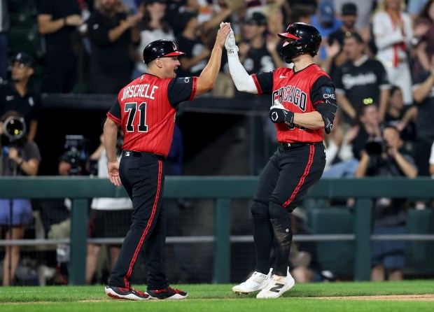 White Sox left fielder Randal Grichuk, right, high-fives third-base coach Justin Jirschele after hitting a solo home run in the sixth against the Mets on Aug. 21, 2026, at Rate Field. (Chris Sweda/Chicago Tribune)