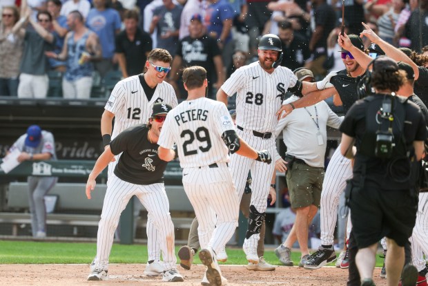 Chicago White Sox players wait to celebrate with center fielder Tristan Peters (29) after he hit a home run in the ninth inning to win the game 2-1 against the New York Mets at Rate Field on Aug. 23, 2026. (Eileen T. Meslar/Chicago Tribune)