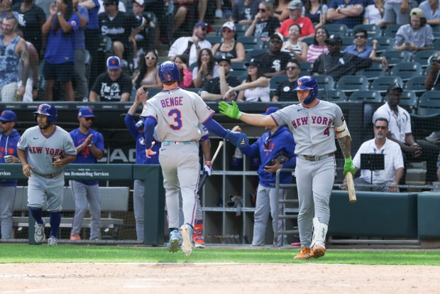 New York Mets catcher Francisco Alvarez (4) high-fives New York Mets right fielder Carson Benge (3) after scoring in the ninth inning against the Chicago White Sox at Rate Field on Aug. 23, 2026. (Eileen T. Meslar/Chicago Tribune)