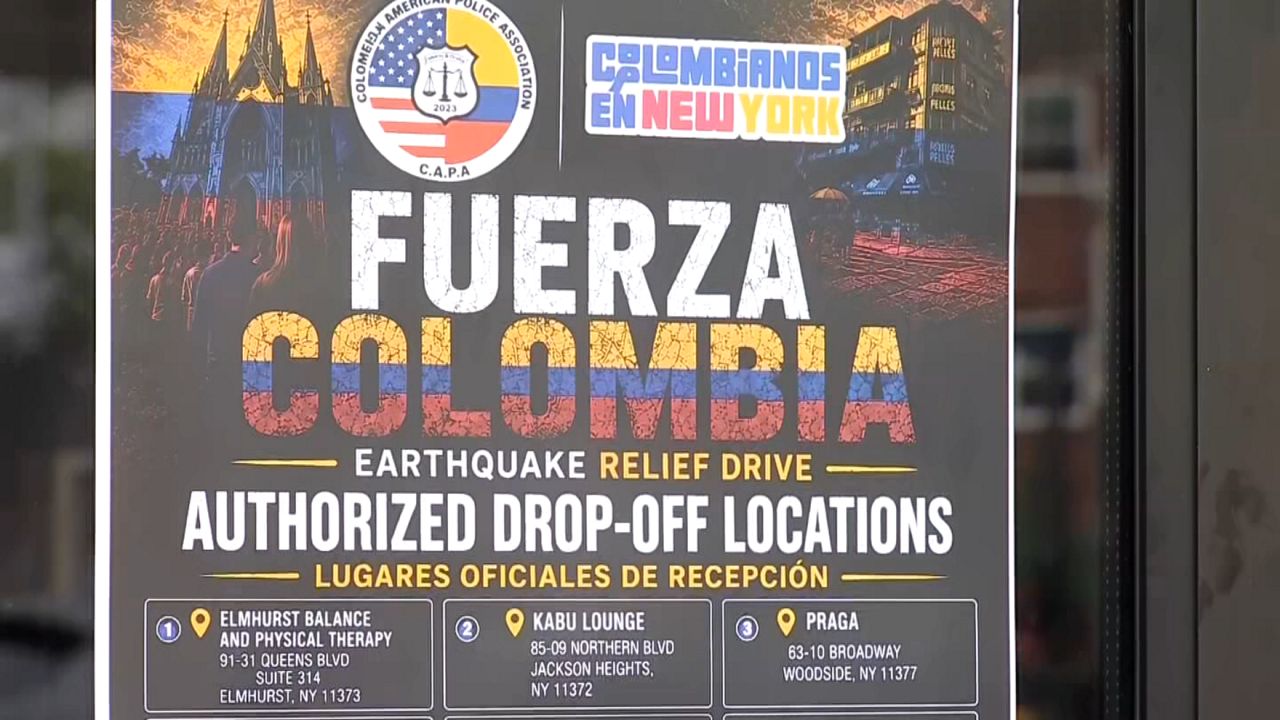 Flags hang outside businesses while boxes of donations are now stacking up inside one of them. (Spectrum News NY1)