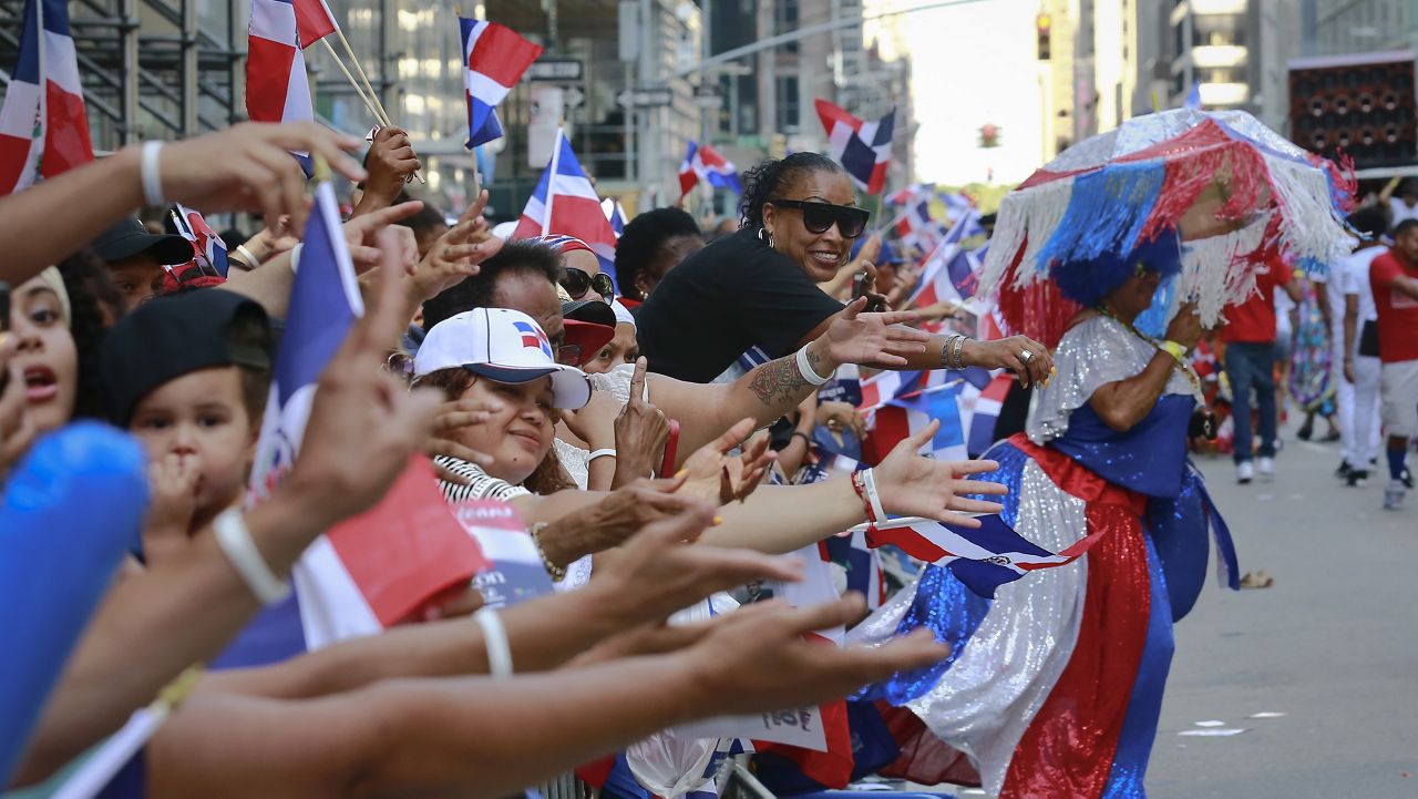 Crowds call for give away souvenirs and cheer during the Dominican Day Parade, Sunday Aug. 13, 2017, in New York. (AP Photo/Bebeto Matthews)