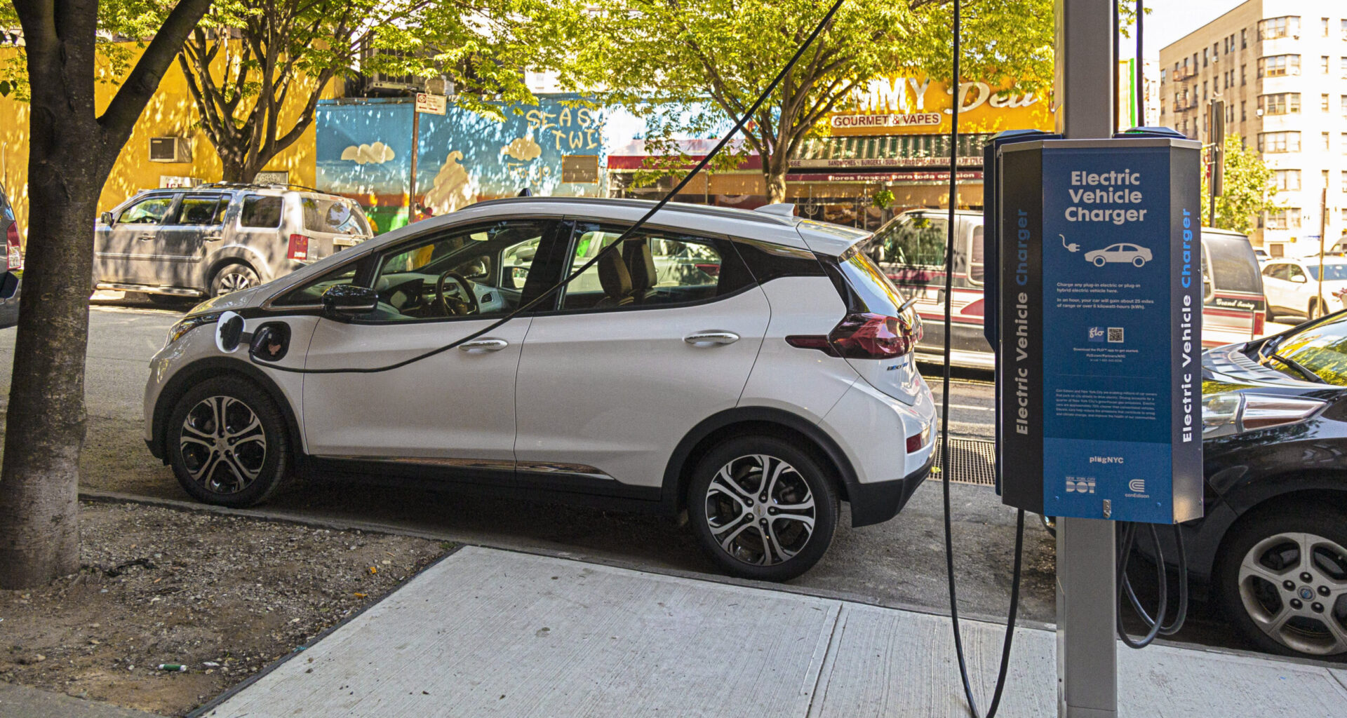 A car plugged into a curbside electric vehicle charger in the Bronx. Bedford-Stuyvesant, Carroll Gardens and Red Hook will soon get these ports as well. Photo: NYC DOT