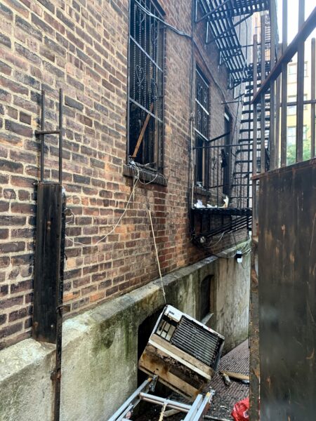 Smashed windows and an air conditioner handing by a wire were left in the fire’s aftermath. Photo: Mary Frost/Brooklyn Eagle