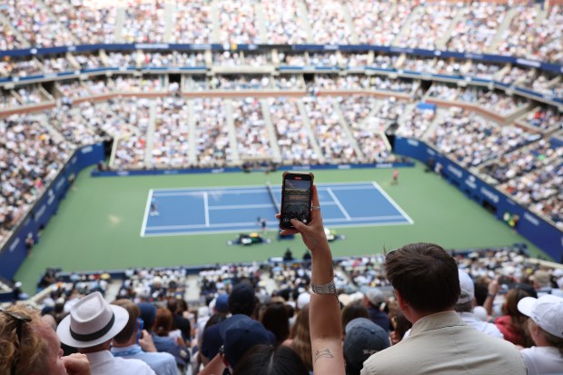 A fan takes a photo during the Men's Semifinal match between Novak Djokovic of Serbia and Carlos Alcaraz of Spain on Day Thirteen of the 2025 US Open at USTA Billie Jean King National Tennis Center on September 5, 2025 in Flushing.