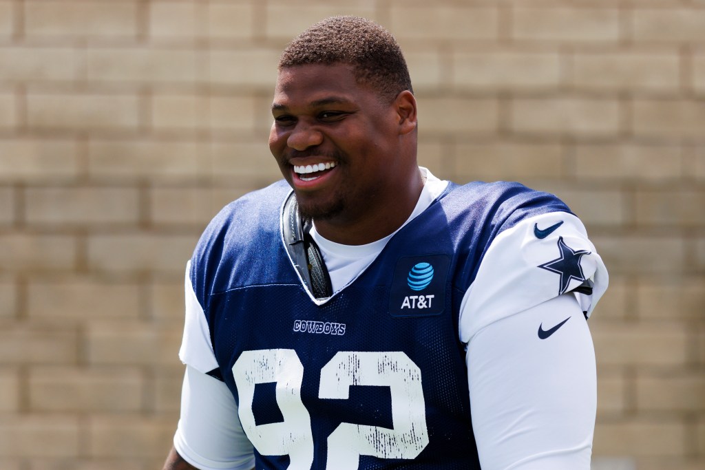 A Dallas Cowboys player smiling in his training camp jersey.