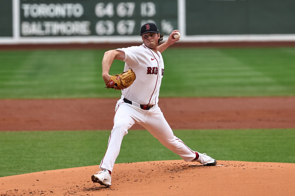 A Boston Red Sox pitcher on the mound throws a baseball.