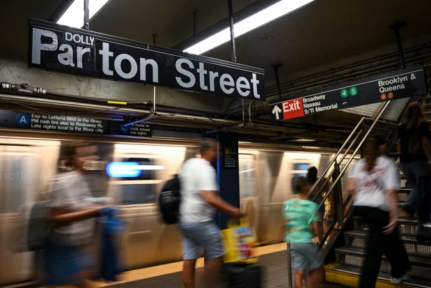 A sign inside the Fulton Street subway station reads 'Dolly Parton Street' as people make their way through the station in Manhattan, New York on Wednesday, Aug. 26, 2026. (Photo by ANGELA WEISS / AFP via Getty Images)