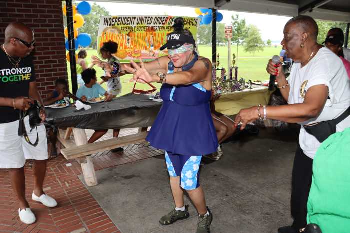 Hyacinth Robinson-Goldson, right, gives direction to a participant in the game, "Find the Donkey’s Tail."