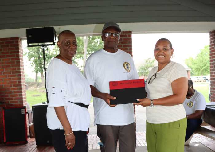 Venice Brydson, right, non-member of the Order and wife of Hon. Michael Brydson, district Grand Deputy Master of Alpha District Grand Lodge #1, receives a special presentation from Hon. Herald Saunders, Sr., the Jamaican-born District Grand Master of the Composite District Grand Lodge #2 and host for the 2026 Family Day Picnic, and Hyacinth Robinson-Goldson, the Jamaican-born IUOM Community Liaison Officer.