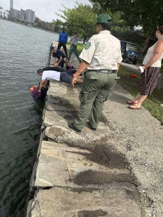 people next to a river helping someone in distress
