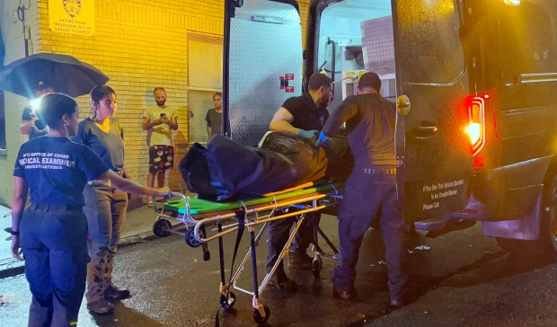 New York City Office of Chief Medical Examiner technicians remove the body of Lester Martin, who was found dead in a five-alarm fire on E. 209th St. in the Bronx on Aug. 5, 2026. (Kerry Burke / New York Daily News)