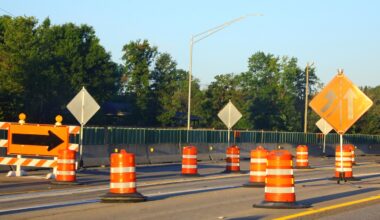 Roadway construction with detour sign and orange barricades