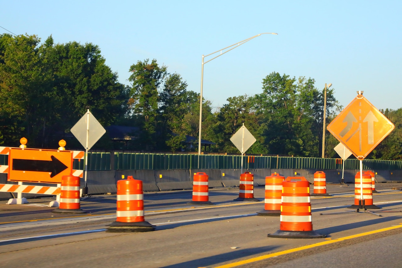 Roadway construction with detour sign and orange barricades