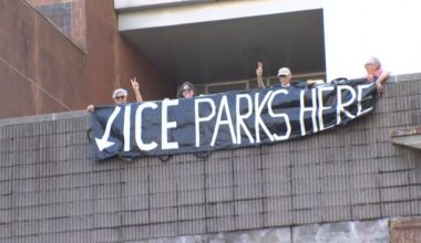 Protesters holding a sign that reads "ICE parks here"