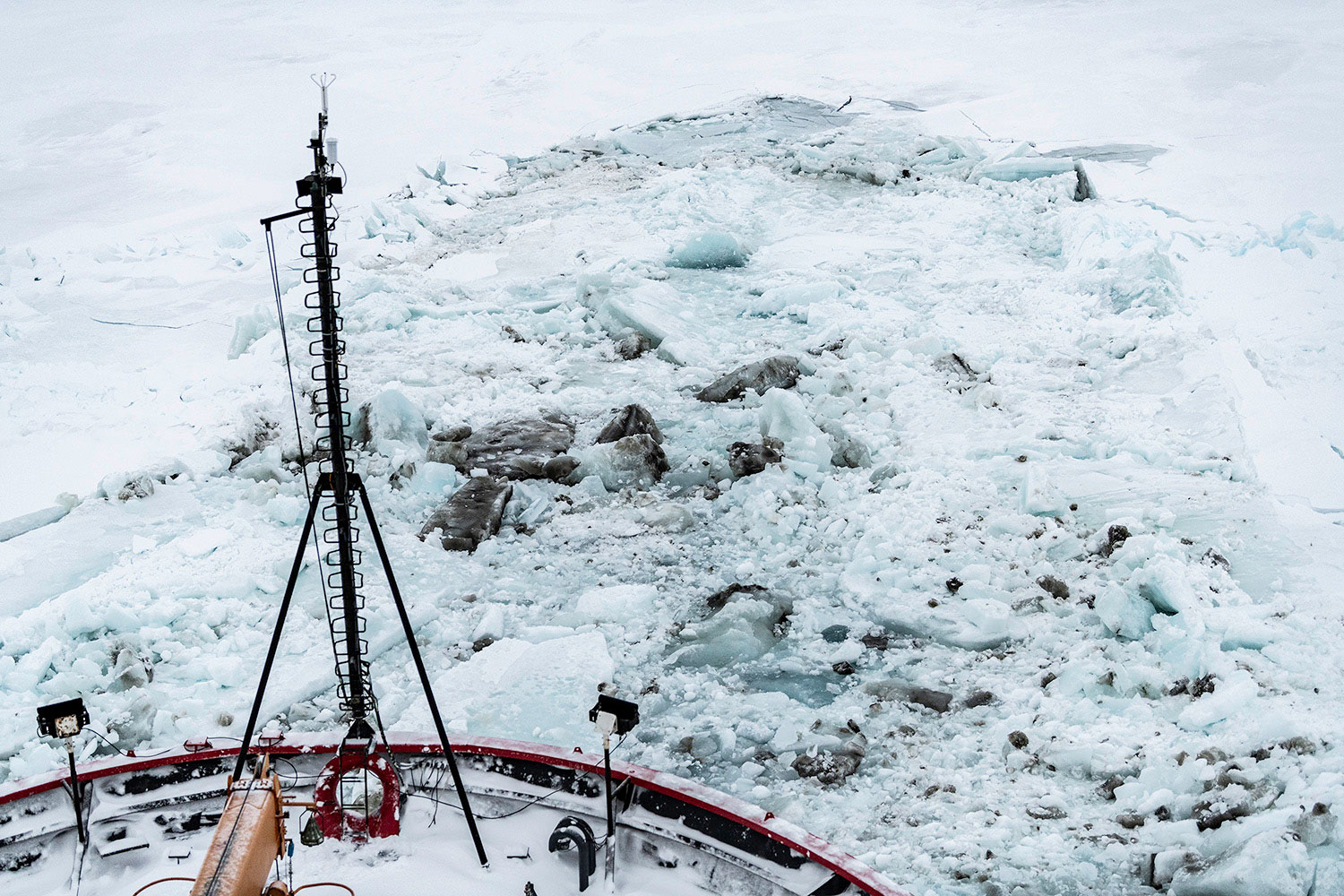 Icebreaker ships nose as it breaks through thick layer of ice