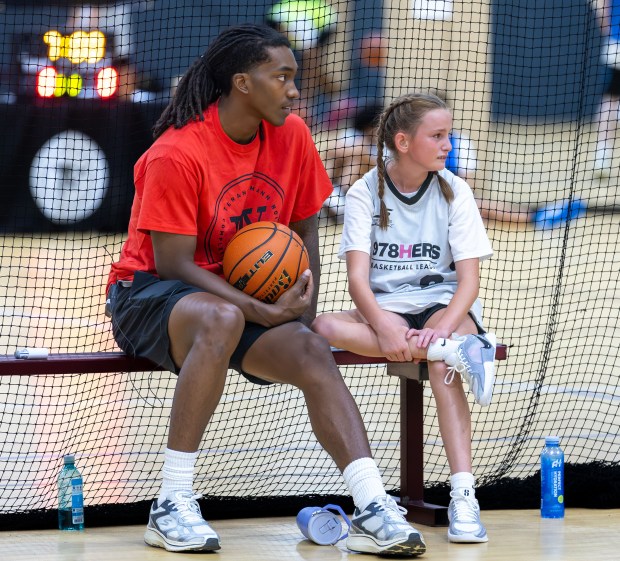 Brooklyn Nets guard and Lowell native Terance Mann sits courtside with a young participant during his basketball camp Thursday. James Thomas for the Lowell Sun
