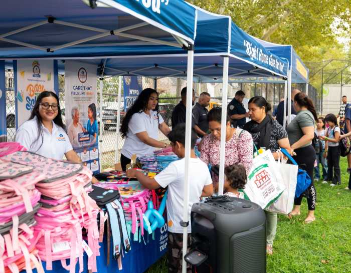Cottage Home Care Services CEO Navin Shivpal, center, joins staff members who helped distribute backpacks and school supplies during the community event.