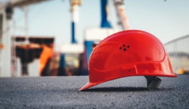 Red hard hat on pavement; image by Ũmit Yildirim, via Unsplash.com.