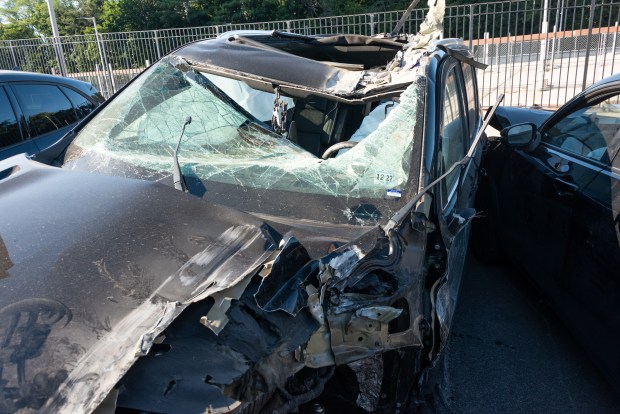 A mangled Cadillac Escalade is pictured in a police lot in Brooklyn, New York on Wednesday, Aug. 26, 2026, after three teens were killed in a late-night crash on the Belt Parkway. (Gardiner Anderson / New York Daily News)