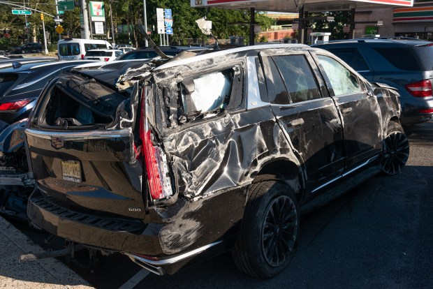 A mangled Cadillac Escalade is pictured in a police lot in Brooklyn, New York on Wednesday, Aug. 26, 2026, after three teens were killed in a late-night crash on the Belt Parkway. (Gardiner Anderson / New York Daily News)