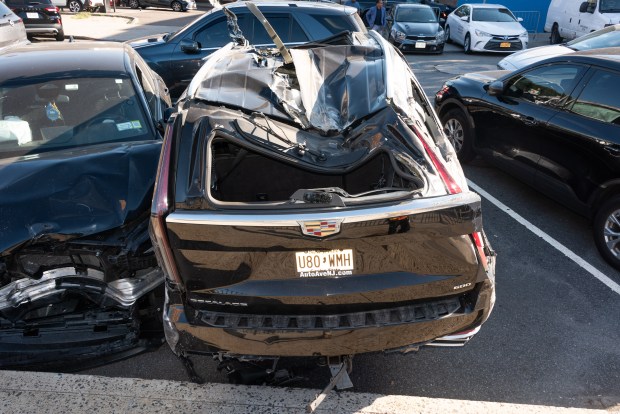 A mangled Cadillac Escalade is pictured in a police lot in Brooklyn, New York on Wednesday, Aug. 26, 2026, after three teens were killed in a late-night crash on the Belt Parkway. (Gardiner Anderson / New York Daily News)
