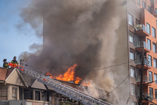 A massive fire ripped through a Queens home on College Point Blvd. near 41st Rd. in Flushing, Queens on Saturday, July 25, 2026, before spreading to two adjoining buildings. (Theodore Parisienne / New York Daily News)