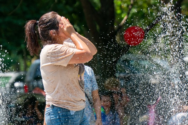 A woman cools off in a sprinkler near Cadman Plaza Park in Brooklyn on Friday, July 25, 2025. (Theodore Parisienne / New York Daily News)
