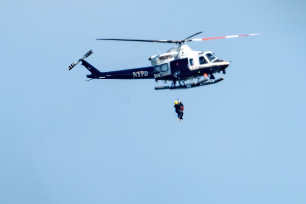A 64-year-old woman is pictured being airlifted to safety by the NYPD after she got lost in the thick brush between Flatbush Ave. and Dead Horse Bay, near the Marine Parkway Bridge connecting Brooklyn to the Rockaways on Sunday, Aug. 2, 2026. (Theodore Parisienne / New York Daily News)