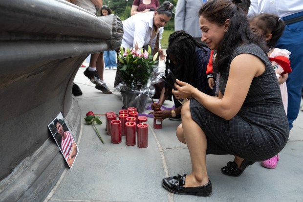 Romanch Mahajan's aunt, Sofia Thukral, lights a candle at a vigil as her son looks on before a press conference in Central Park on Monday, July 27, 2026 in New York City. (Barry Williams/ New York Daily News)
