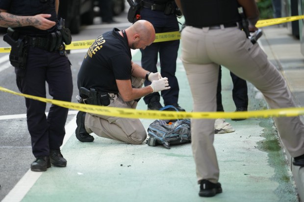 Police investigate after a backpack carried by John Butch, 65, burst into flames at a lower Manhattan office building on Friday.