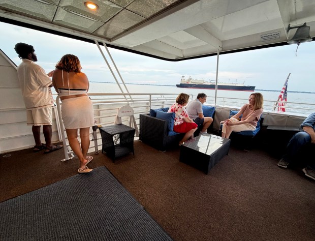 Several guests gather at the stern of the Manhattan Elite during Thursday, August 27, 2026, evening's sunset cruise. (Stephen M. Katz / The Virginian-Pilot)