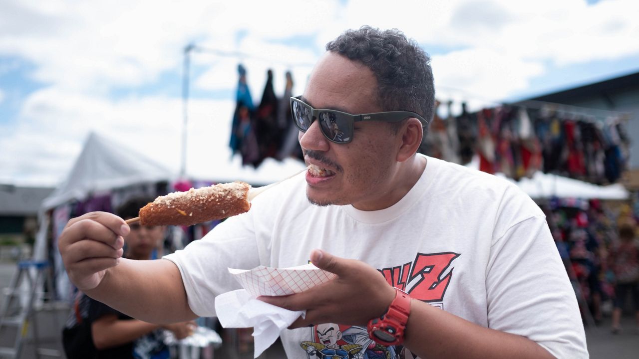 A man at the fair last year eats a Korean corn dog