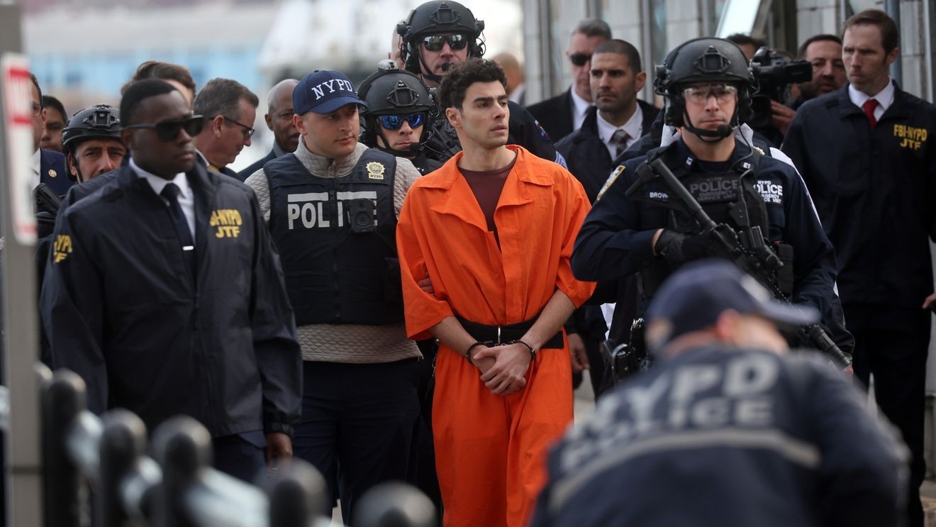 NEW YORK, NEW YORK - DECEMBER 19: Luigi Mangione, suspect in the killing of UnitedHealthcare CEO Brian Thompson in New York City, arrives at a heliport with members of the NYPD on December 19, 2024 in New York City. The 26-year-old was arrested in Pennsylvania on December 9 after being spotted at a McDonald's in Altoona amid a national manhunt. Mangione also appeared in a Pennsylvania court on forgery and firearms charges today, where he waived extradition to New York after being indicted on 11 charges including first-degree murder in furtherance of terrorism. (Photo by Spencer Platt/Getty Images)