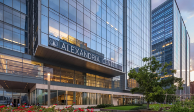 Glass building labeled "Alexandria Center" with reflective windows