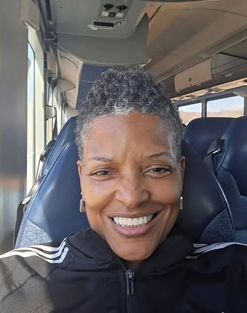 Alisa Goods smiling for a selfie while sitting on a bus.