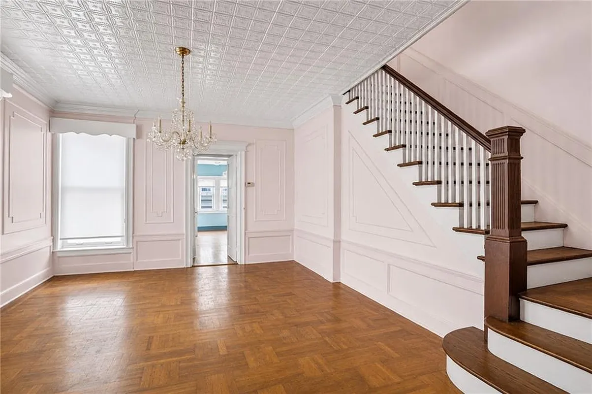 dining room with wall moldings, tin ceiling, staircase