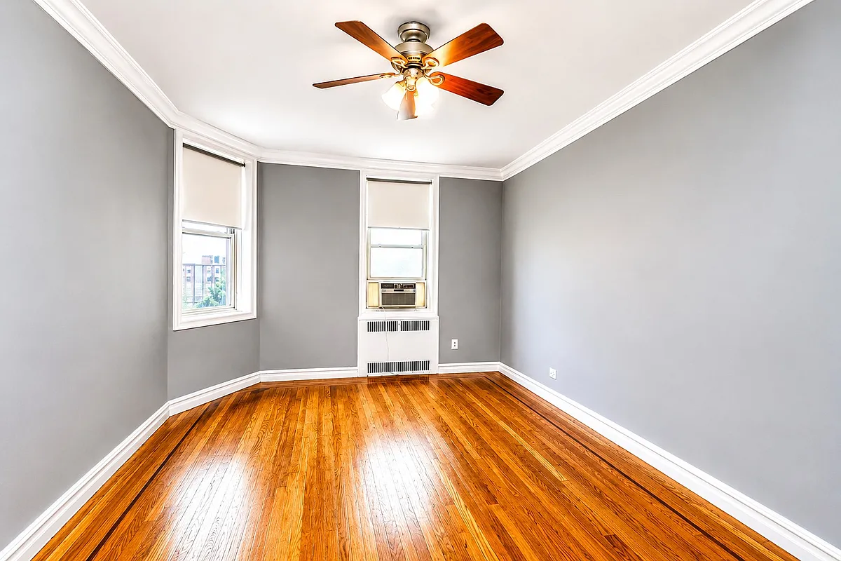bedroom with two windows, ceiling fan, wood floor