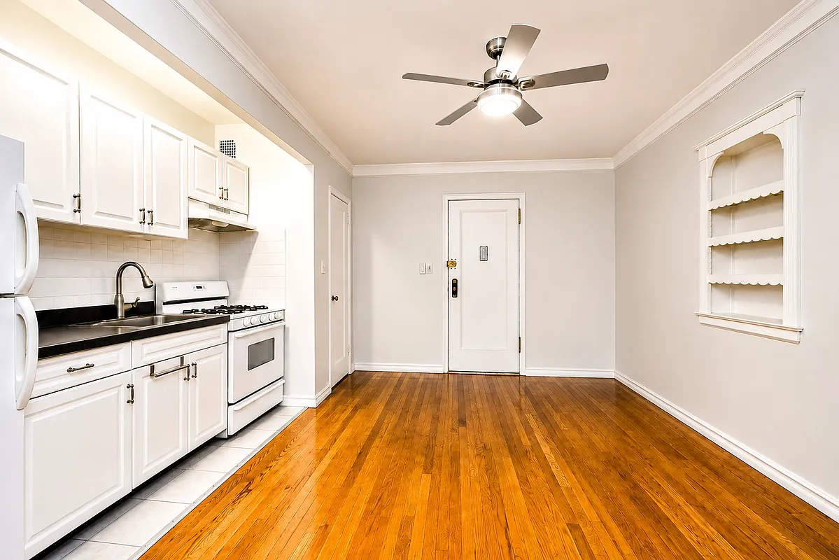 entry with a niche with shelves and a kitchen in an alcove