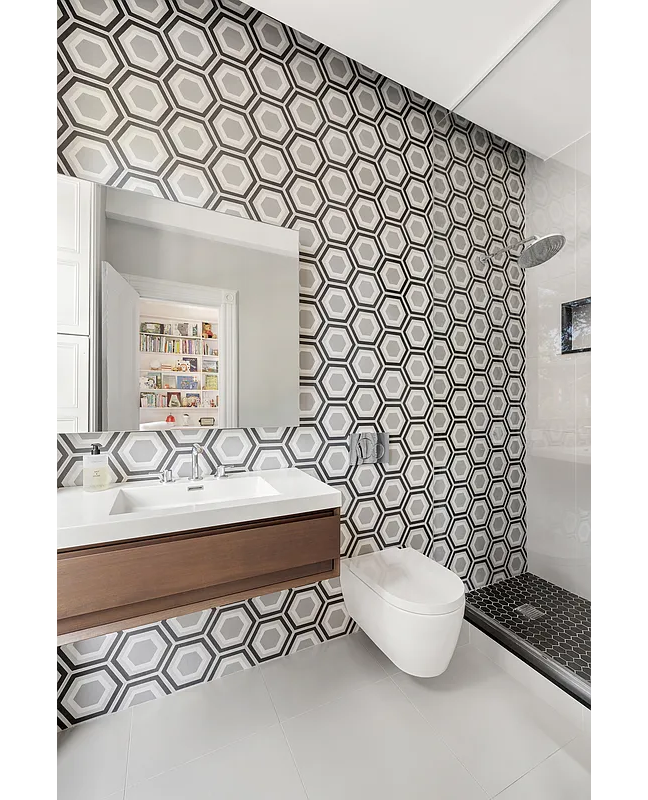 bathroom with a shower, floating vanity and graphic wallpaper